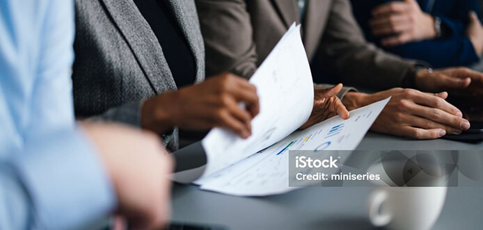 A person in a business meeting looking through papers