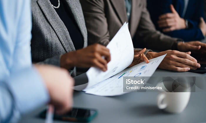 A person in a meeting looking through paperwork